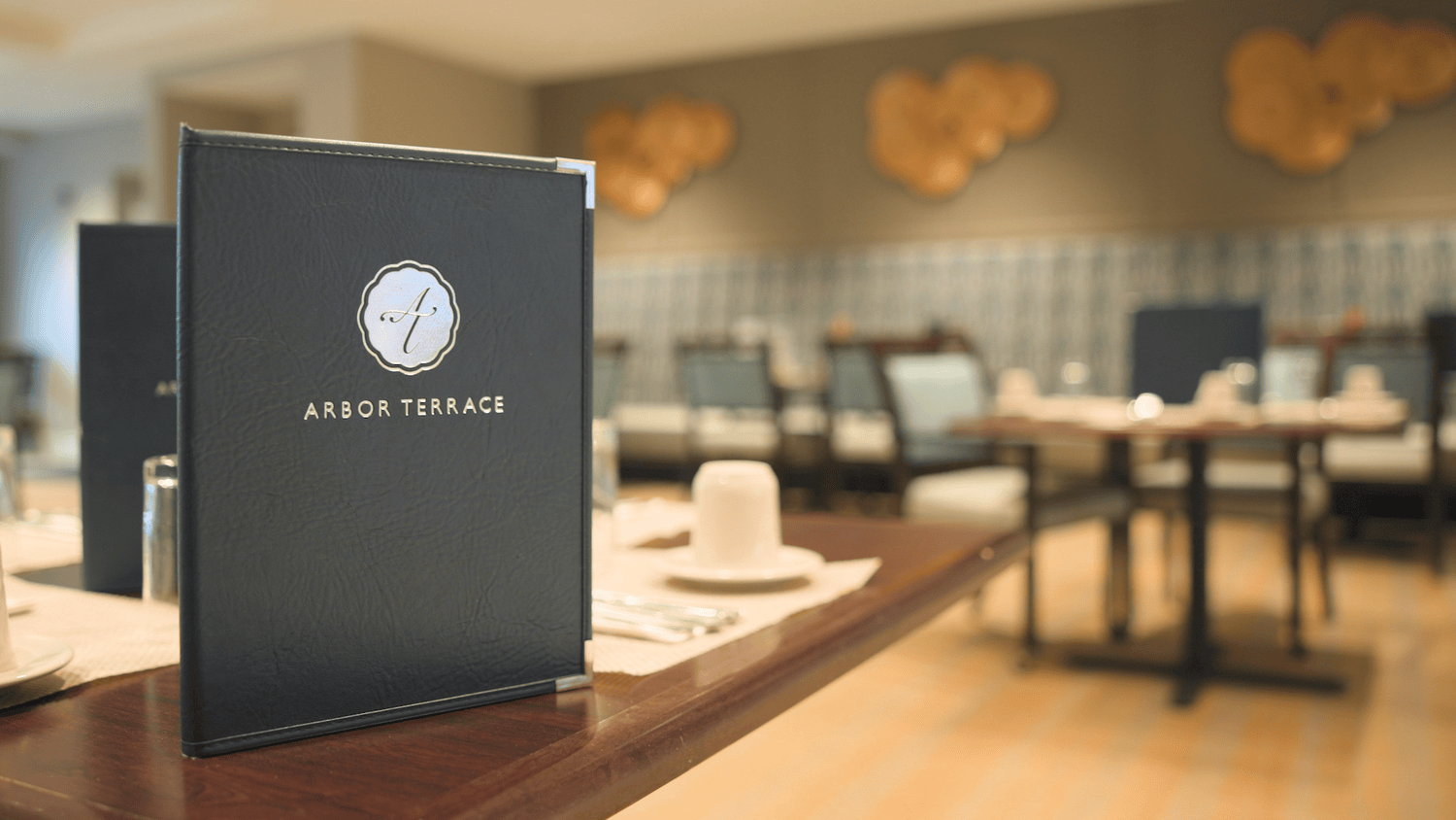 A place setting with a menu awaits guests in the dining room at Arbor Terrace Glenview senior living, showcasing senior living with gourmet dining North Shore.