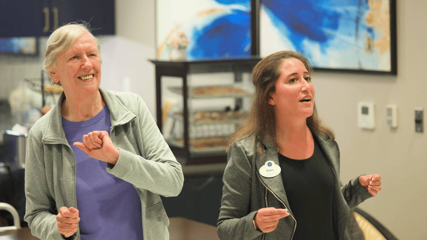A staff member and resident dance together during a lively activity at Arbor Terrace Glenview senior living, embracing the active senior lifestyle Glenview is known for.