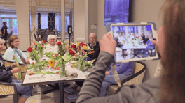 Residents at Arbor Terrace Glenview senior living gather around a table filled with fresh flowers during a group activity, embracing the active senior lifestyle Glenview IL provides.