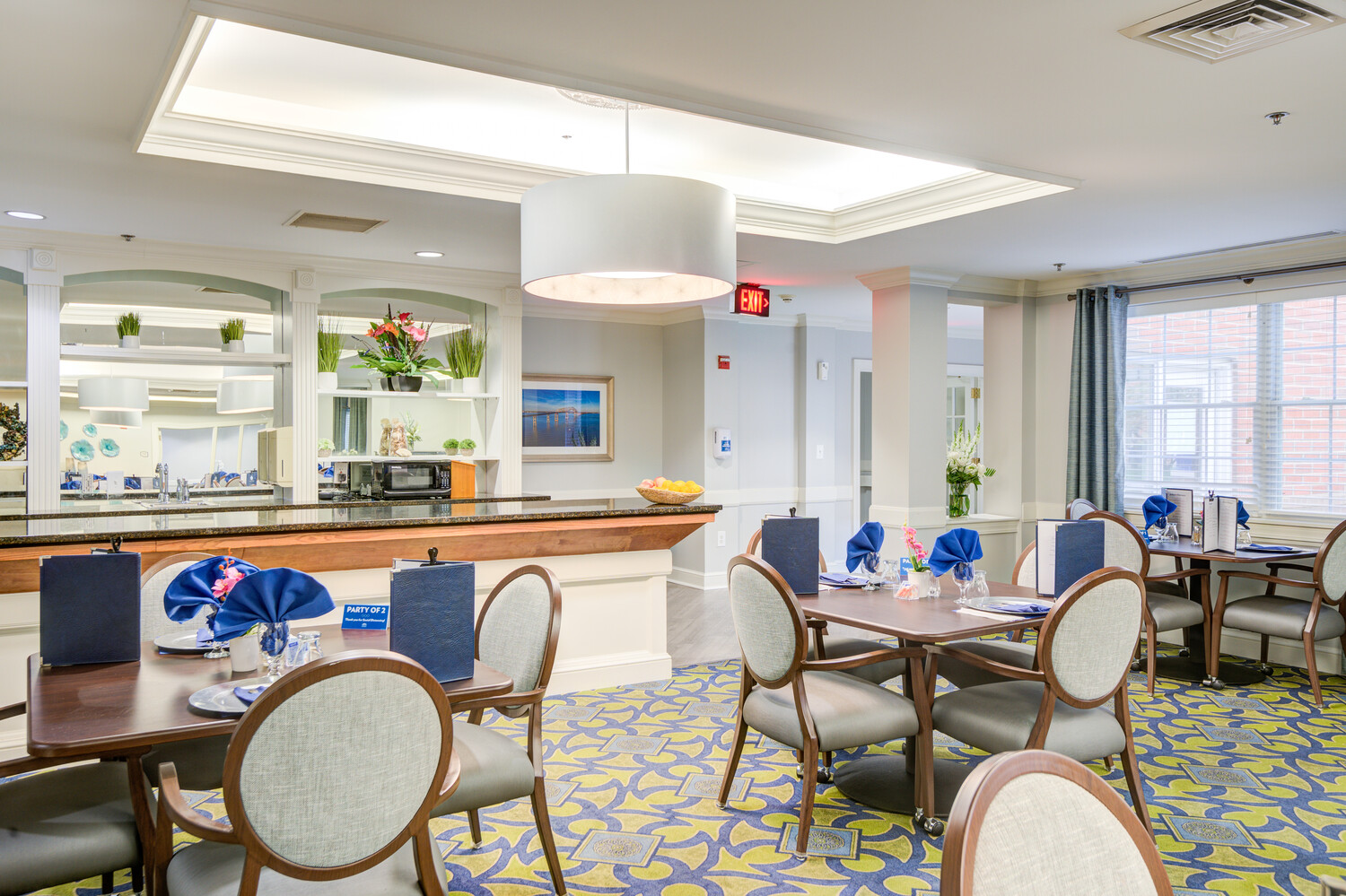 Spacious dining room with multiple seating areas and a visible serving station at Arbor Terrace, a warm assisted living community near Greenbelt, MD.