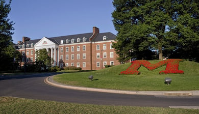 The iconic University of Maryland campus entrance with its red and green floral letter M, just a short drive from this senior living community in Lanham, MD.