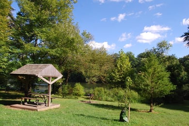 A shaded wooden pavilion nestled among tall trees in Greenbelt Park, just minutes from this senior living community near parks and recreation in Lanham, MD.