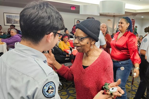 Residents and an entertainer share a joyful moment during a lively music performance at this senior living community in Lanham, MD, where social activities and live events bring the community together.