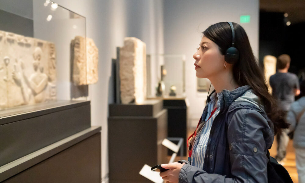 A visitor exploring exhibits at a museum with an audio guide, reflecting the rich cultural experiences near Arbor Terrace, an active senior living community in Lanham, MD near Greenbelt.