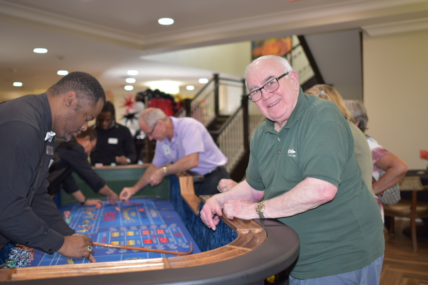 A senior enjoys a lively casino night event at this senior living community near Hamilton Mill, GA, taking part in the vibrant social activities and entertainment offered.
