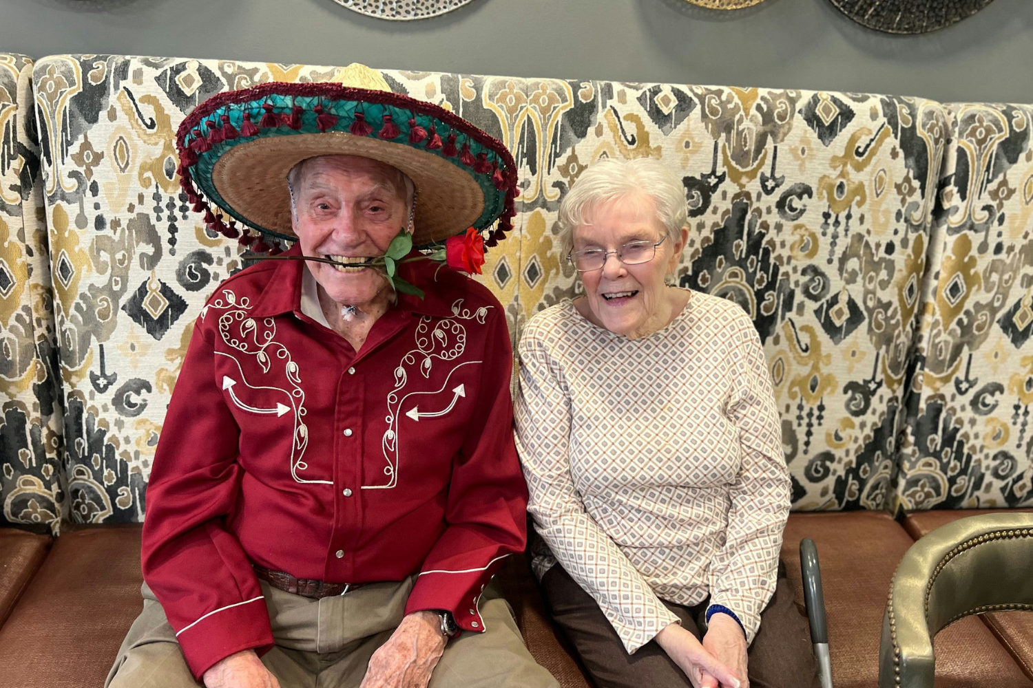 Two seniors share a big smile while dressed up in festive Cinco de Mayo attire at this senior living community in Dacula, GA, celebrating with fun and spirited community events.