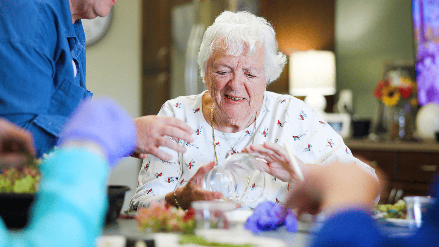 A senior engages in a hands-on floral arranging activity at this senior living community near Hamilton Mill, GA, enjoying enriching programming in a warm and supportive setting.
