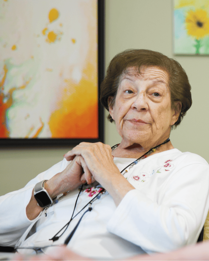 A senior relaxes comfortably in a cheerful common area decorated with colorful artwork at this senior living community in Dacula, GA, enjoying a peaceful and bright setting.