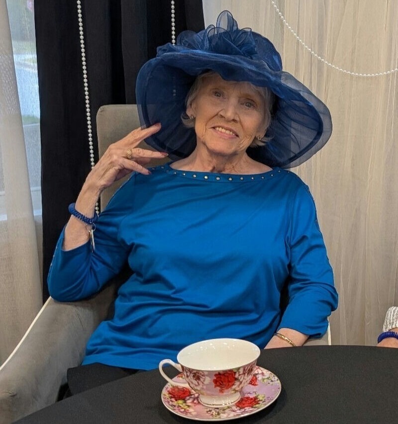 A senior resident smiles elegantly while enjoying a morning cup of tea, embracing the relaxed and fulfilling independent senior apartments Dacula GA lifestyle.