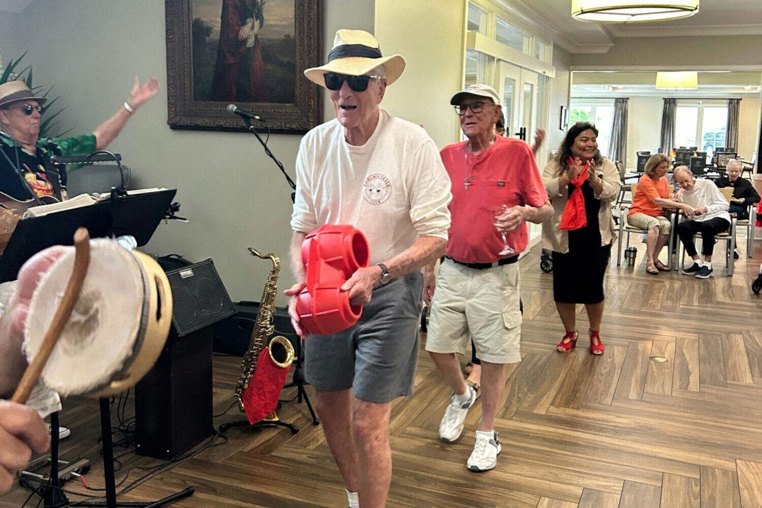 Seniors and staff dancing and celebrating together during a live music performance inside the community — a joyful snapshot of the social and engagement-focused senior living Gwinnett County residents love.