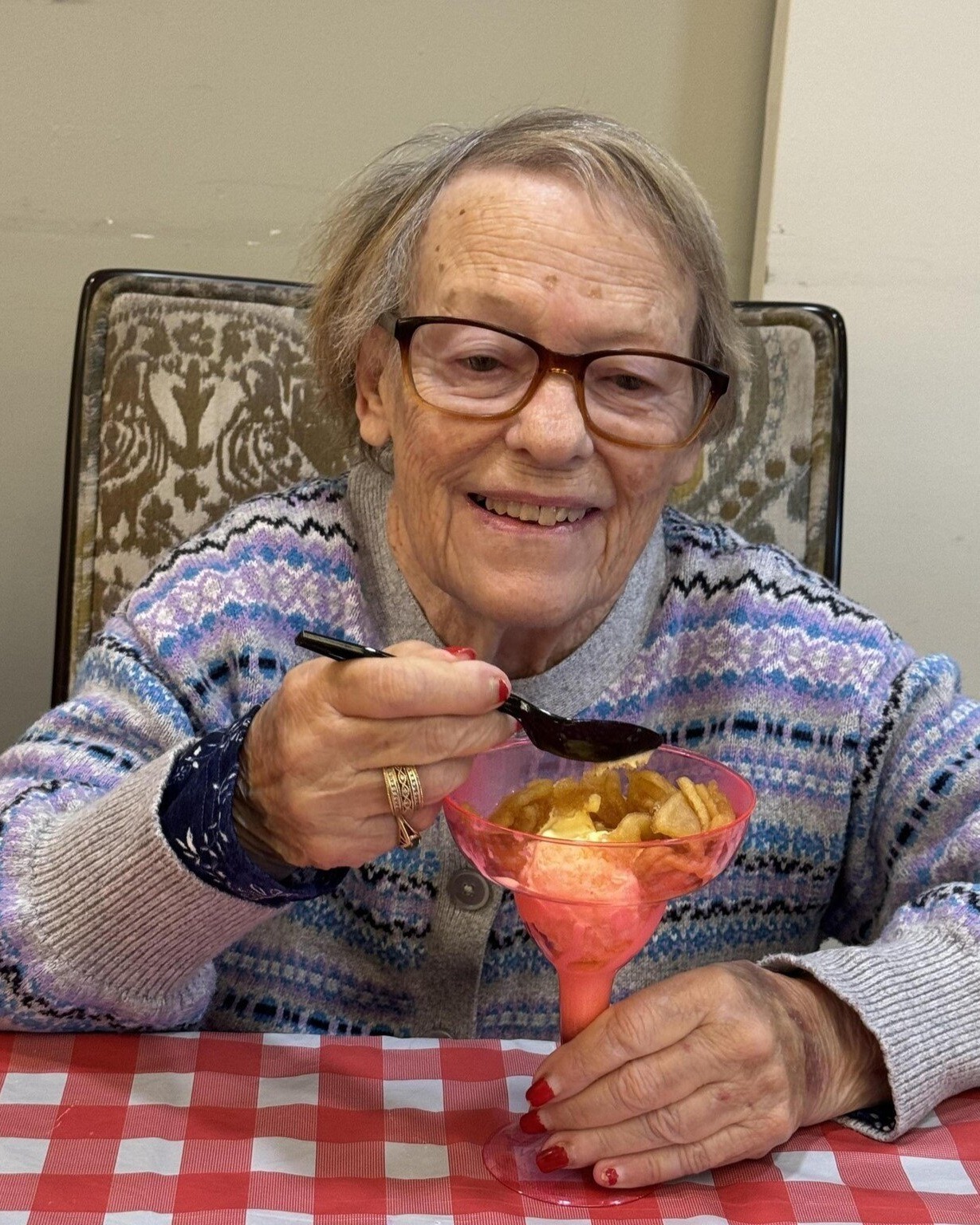 A senior resident smiles brightly while enjoying a colorful beverage, capturing the active senior lifestyle Dacula residents experience every day.