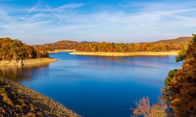 A scenic lake surrounded by colorful autumn foliage at Little Mulberry Park, a peaceful nature destination just 15 minutes from this senior living community near Hamilton Mill, GA.