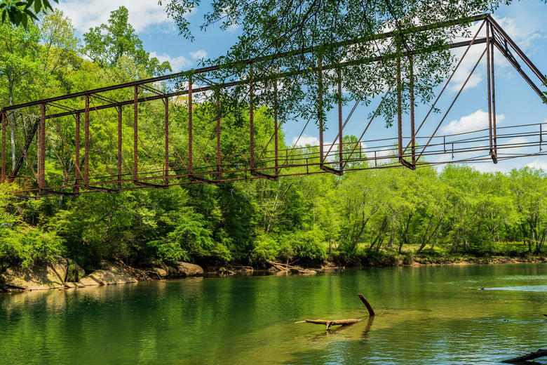 A historic iron bridge surrounded by lush greenery in Buford, an established suburban hub just minutes from this senior living community near Hamilton Mill, GA.