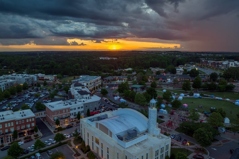 A warm sunset aerial view of Suwanee, a walkable Gwinnett County town center community just a short drive from this senior living community near Hamilton Mill, GA.