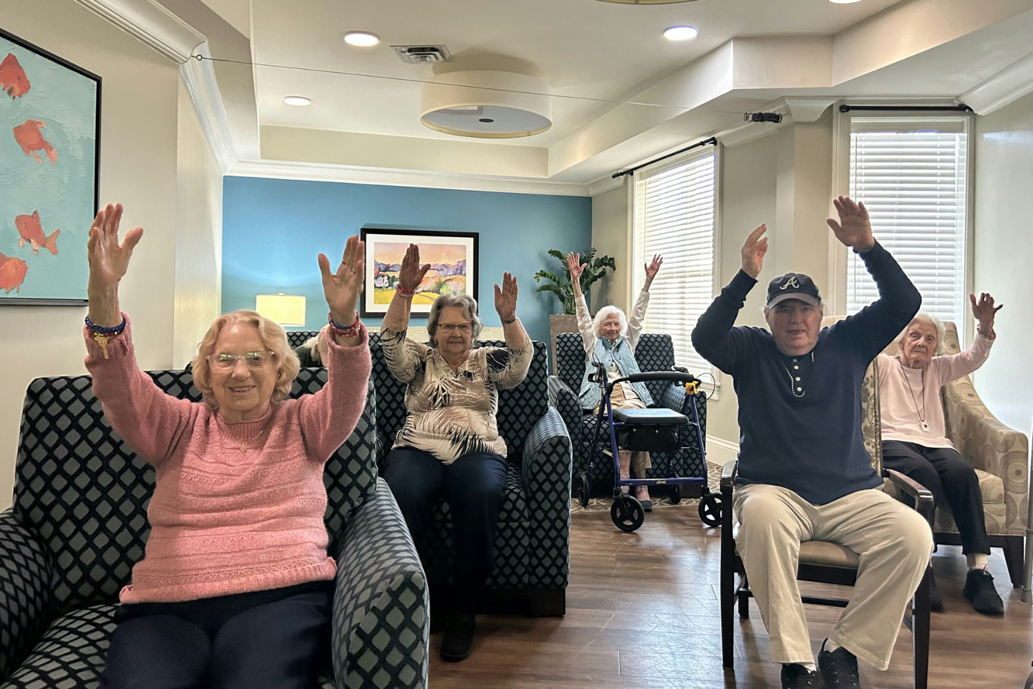 Senior residents smiling and participating in seated exercise