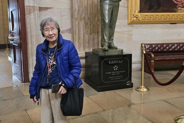 A resident smiles warmly beside a historic bronze statue in a grand marble hall, capturing a memorable cultural outing enjoyed through the active senior living Herndon VA lifestyle at Arbor Terrace Herndon, a senior living Herndon Virginia community.