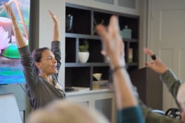 Residents raising their arms during a fitness class at Arbor Terrace Highland Park, a senior living community in Highland Park, IL.