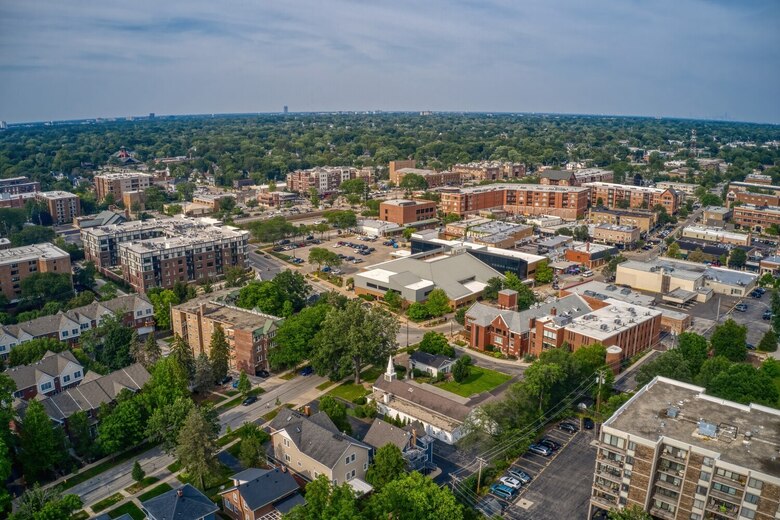 Aerial view of a historic town with brick buildings, tree-lined streets, and neighborhoods stretching toward the horizon, a charming area for families exploring memory care Lake Forest IL and top senior living communities Lake County IL.