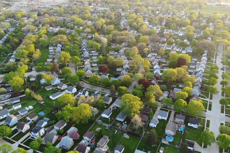Aerial view of a leafy neighborhood with rows of homes tucked among green trees and quiet streets, a familiar setting for families exploring assisted living Deerfield IL and a short drive to a Highland Park IL assisted living community.