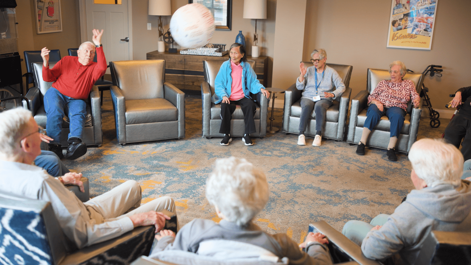 Residents toss a soft ball during a lively group activity in a cozy lounge, part of the active senior lifestyle at our senior living community in Highland Park, IL.