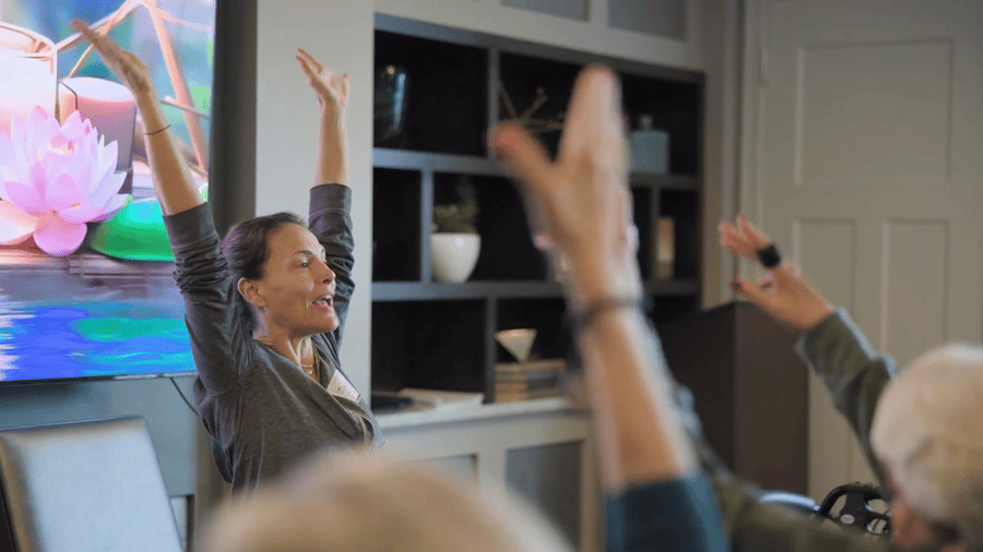 A wellness instructor leads residents through an energizing stretch class at Arbor Terrace Highland Park, encouraging the active senior lifestyle in Highland Park, IL. Wellness-focused senior living brings mind and body together.