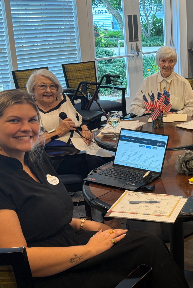 Two senior ladies using a microphone to record a podcast with female staff member