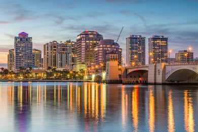 The glittering West Palm Beach skyline at dusk, a regional cultural and medical hub serving residents and families of this senior living community in Lake Worth, FL.