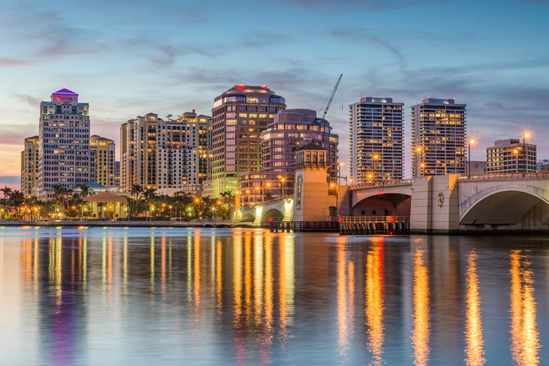 The glittering West Palm Beach skyline at dusk, a regional cultural and medical hub serving residents and families of this senior living community in Lake Worth, FL.