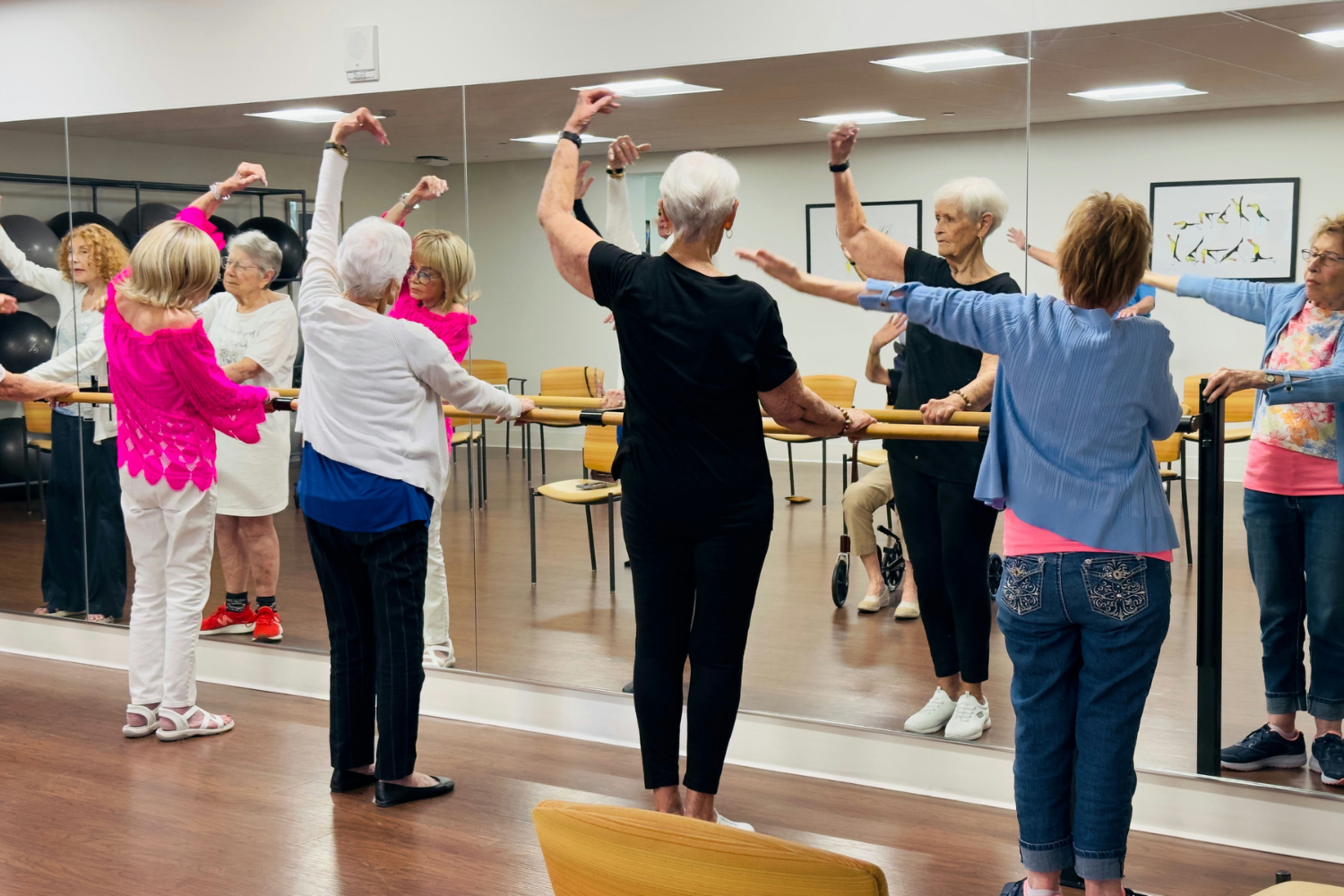 Senior ladies doing ballet exercises during barre class
