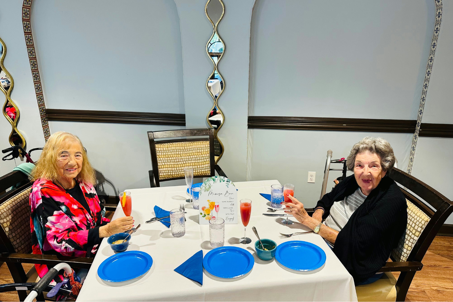 2 women sitting at a table with drinks