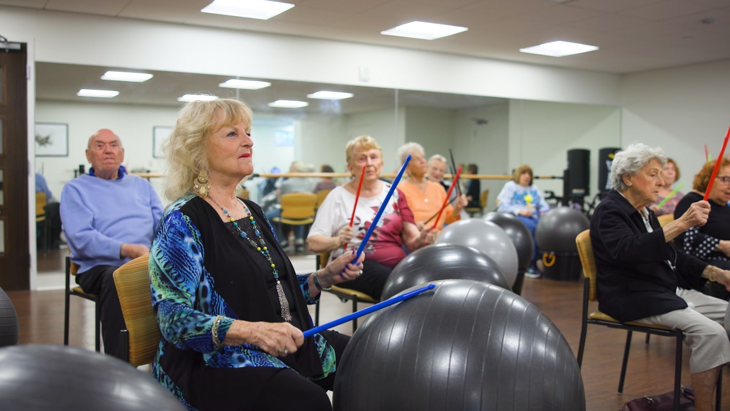 Residents participate in an engaging exercise class using resistance bands and stability balls at this wellness-focused senior living Lake Worth FL community.
