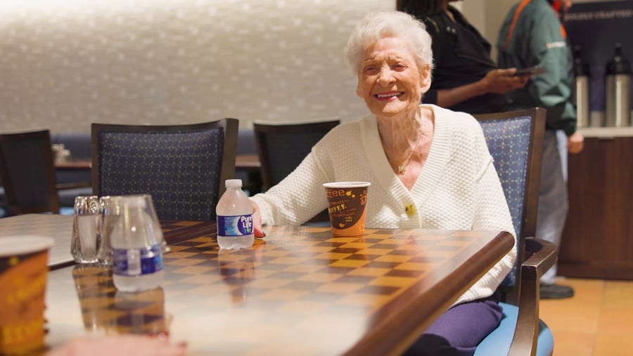 a senior lady sitting by a table