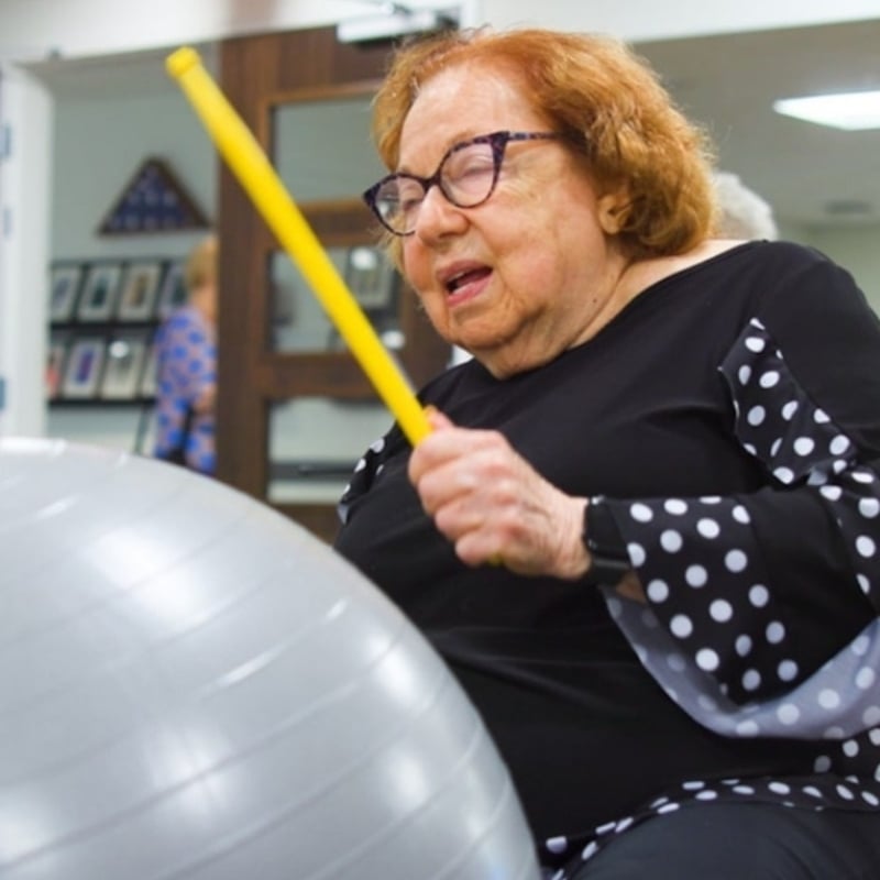 Senior Lady doing drums workout in the fitness room