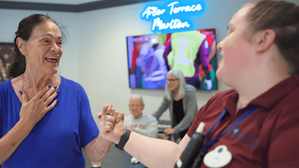 senior resident dancing with staff