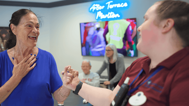 senior resident dancing with staff