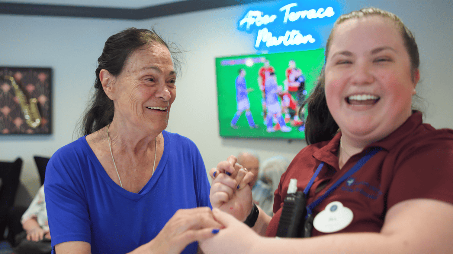 Arbor Terrace Marlton resident and staff smiling and holding hands