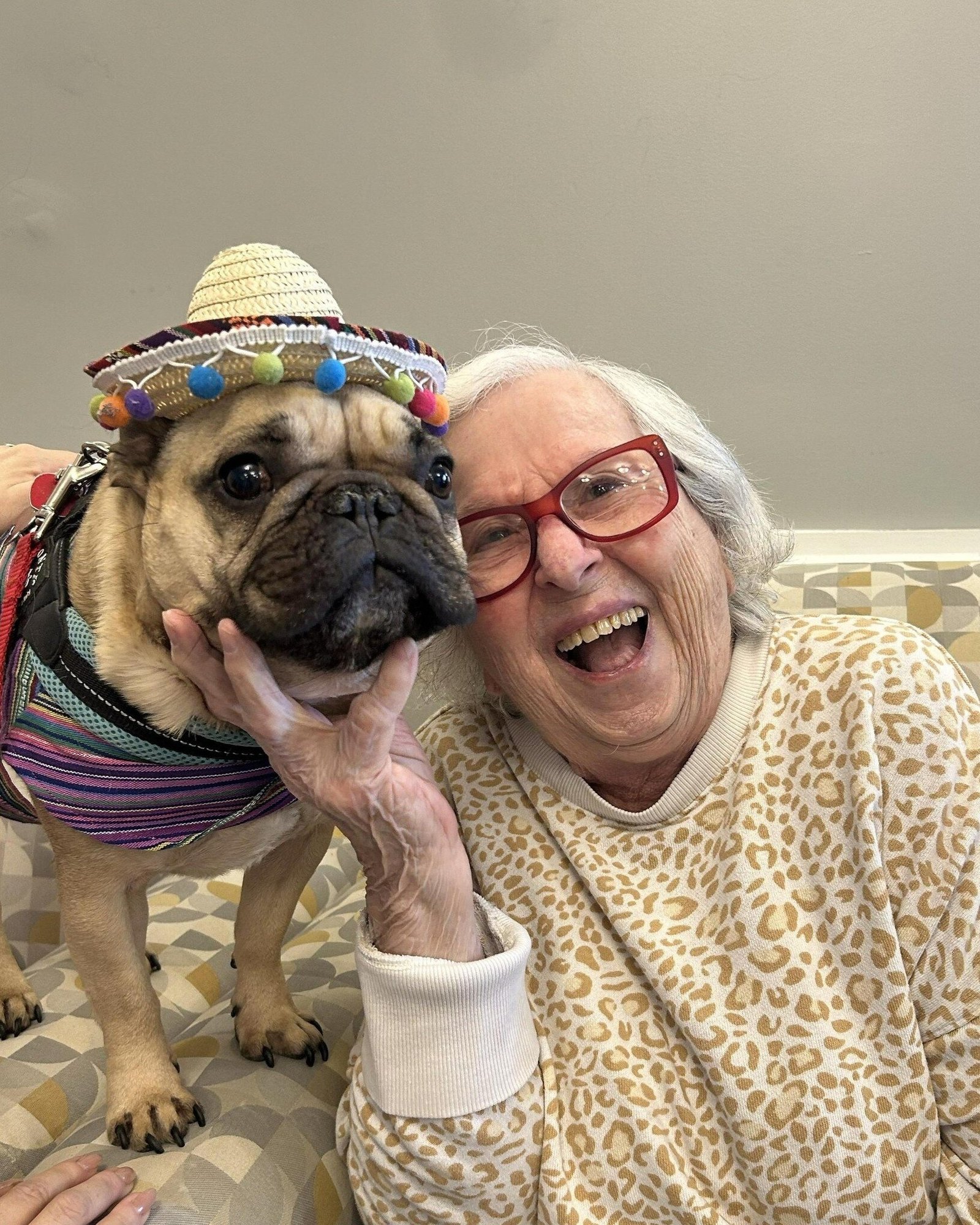 Middletown_Resident happily smiles with a pup wearing a hat