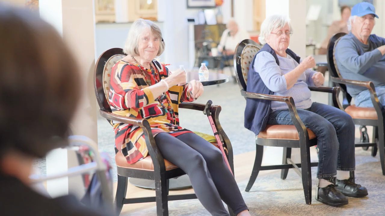 Residents smile and engage during a group activity in a bright, welcoming common area at this retirement community in Middletown NJ, enjoying a lively and engaging afternoon together