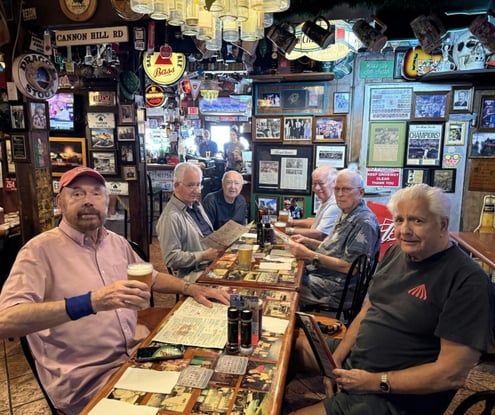 Residents enjoying a lively outing together at a local bar, laughing and sharing drinks — a glimpse of the vibrant social life at an active senior living community in Miami, FL.