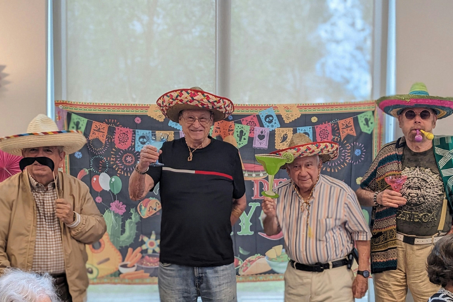 Residentes y miembros del equipo celebran el Cinco de Mayo con sombreros festivos y decoraciones coloridas en Mirabelle, comunidad de senior living en Miami, FL.
