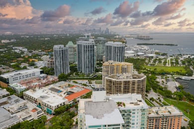 An aerial view of Coconut Grove's waterfront skyline and bayside streets, a beloved neighborhood near this senior living community in Miami, FL, known for its galleries and walkable charm.