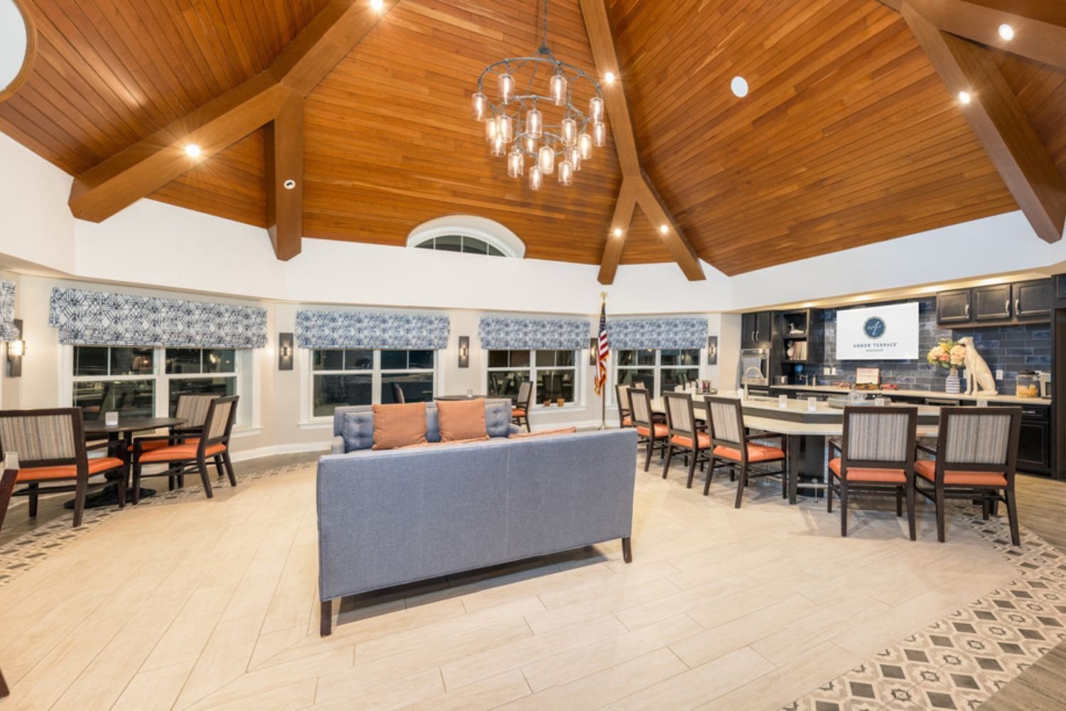 a room with various comfy seating/table options and a TV in Arbor Terrace Monmouth