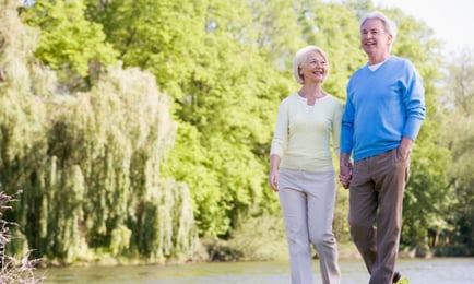 two seniors walking in a park