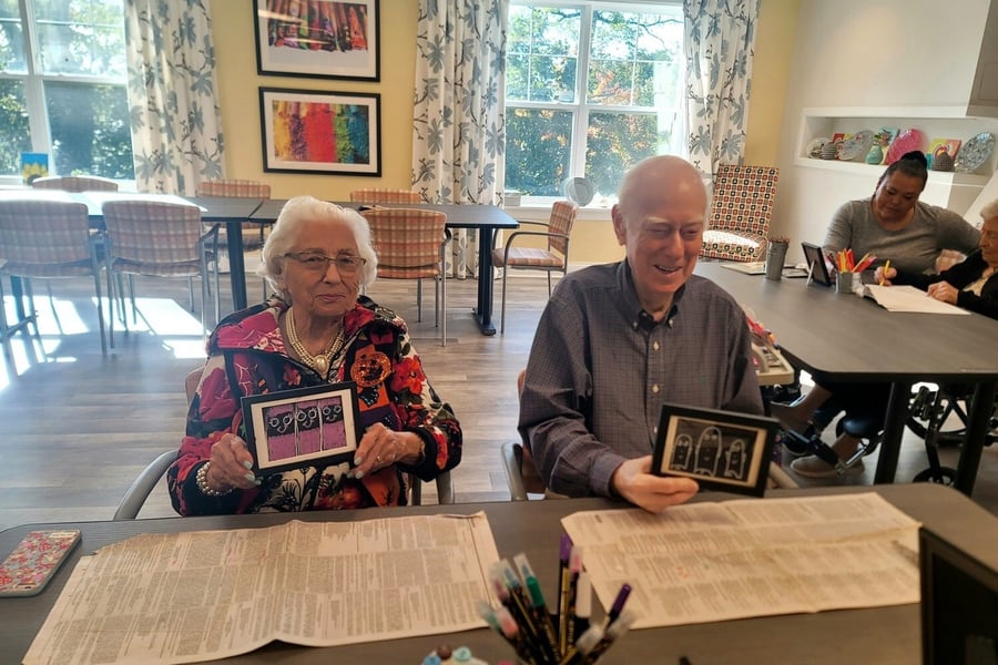 two residents holding photo frames