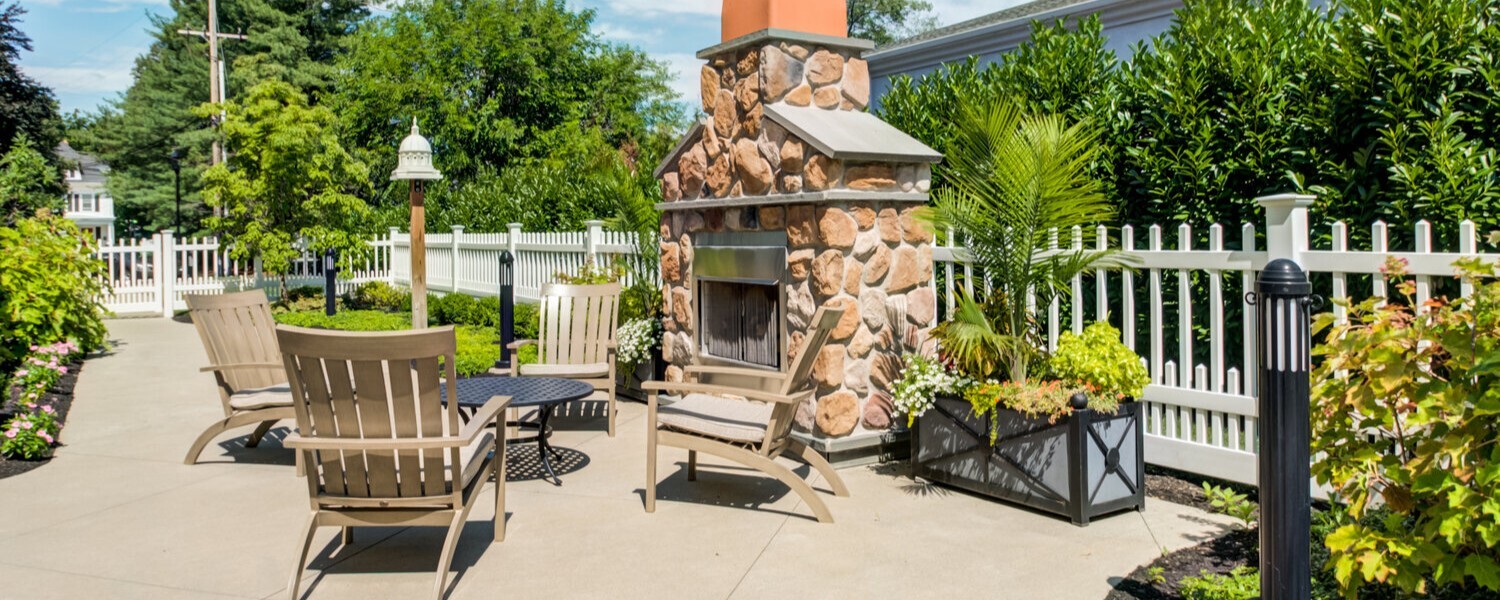 Outdoor patio with fireplace at Arbor Terrace Morris Plains, a senior living community in Morris Plains, NJ, designed for residents to enjoy the outdoors in a peaceful, serene environment