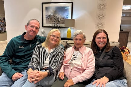Four people smile warmly together on a couch in a bright, welcoming lounge at Arbor Terrace Morris Plains, capturing the warm sense of community found in personalized assisted living in Morris Plains, NJ.