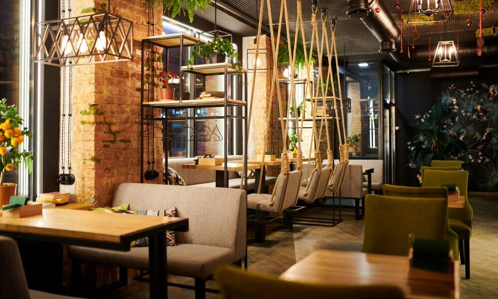 Modern, cozy dining area in a restaurant, featuring stylish pendant lighting and comfortable seating.