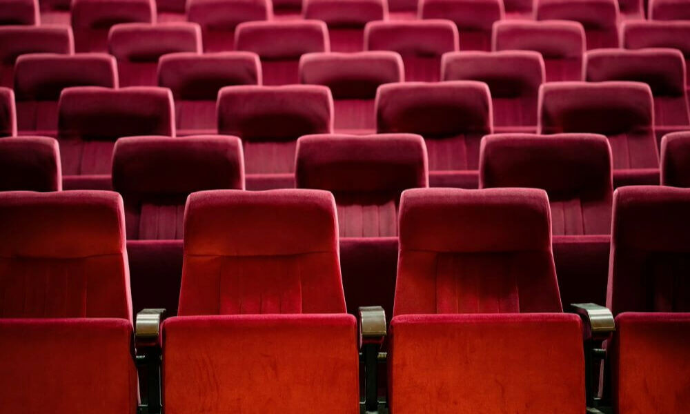 Empty red theater seats in a movie theater, arranged in neat rows.