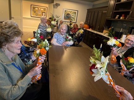 A group of senior ladies arranging flowers during a springtime activity at a senior living community in Norwood, NJ