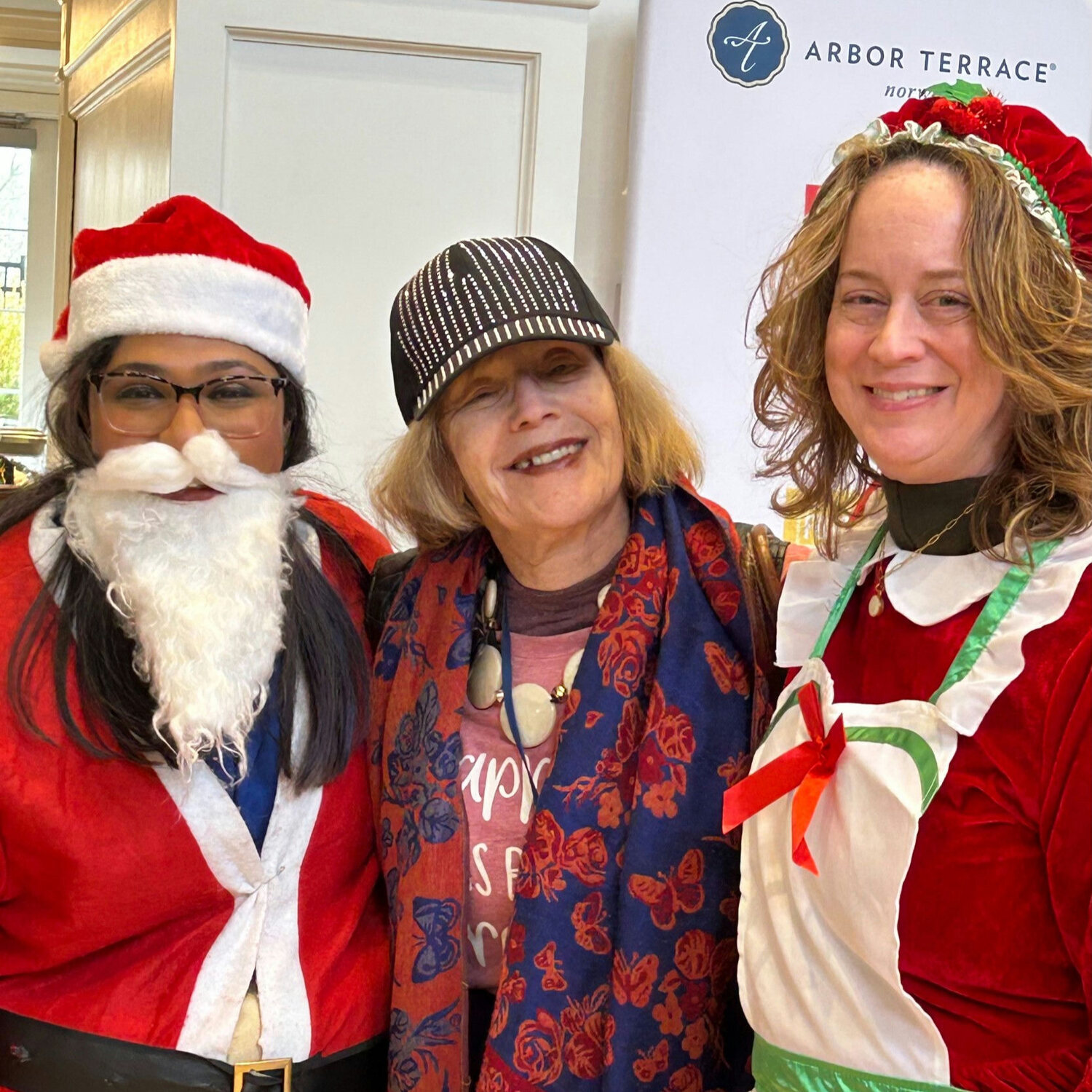 A resident and staff members wearing holiday-themed outfits